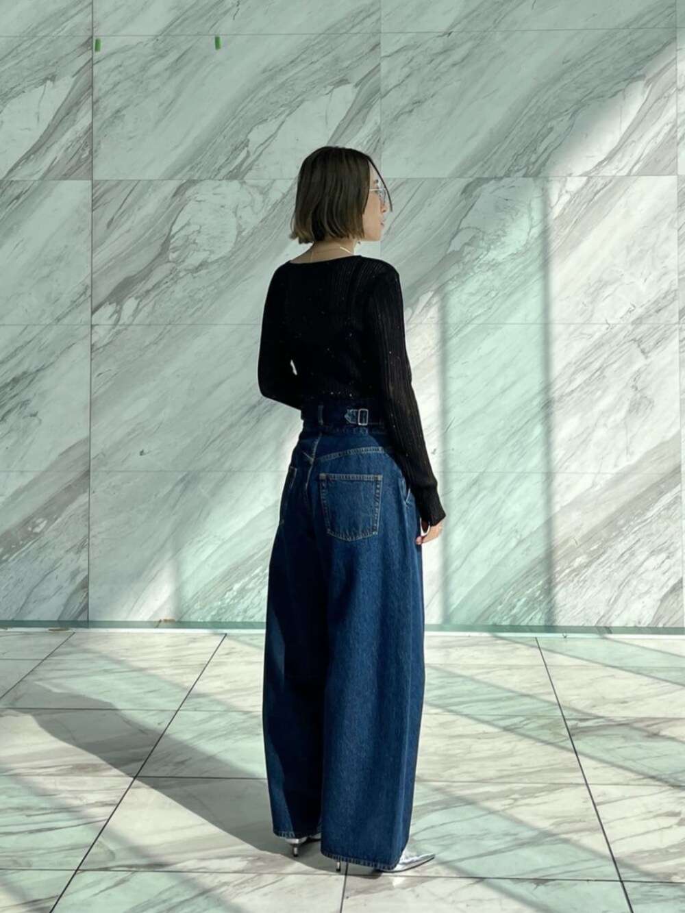 ブルー系のデニムパンツ、ブラック系のニット/セーターを着用したレディースの冬コーディネートの2枚目の写真