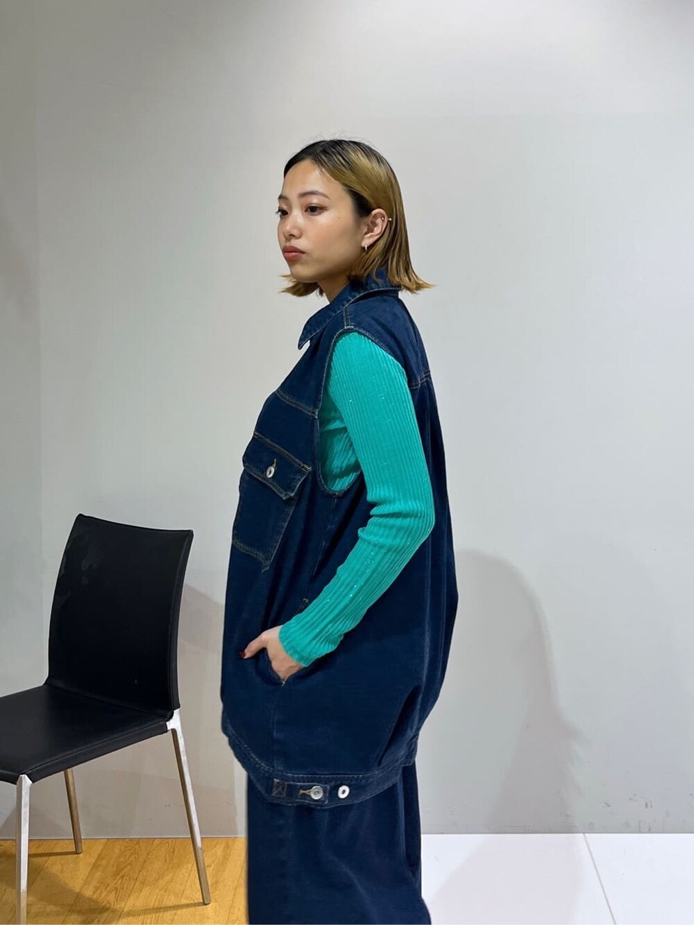 ブルー系のデニムジャケット、グリーン系のニット/セーター、ブルー系のデニムパンツを着用したレディースの冬コーディネートの6枚目の写真