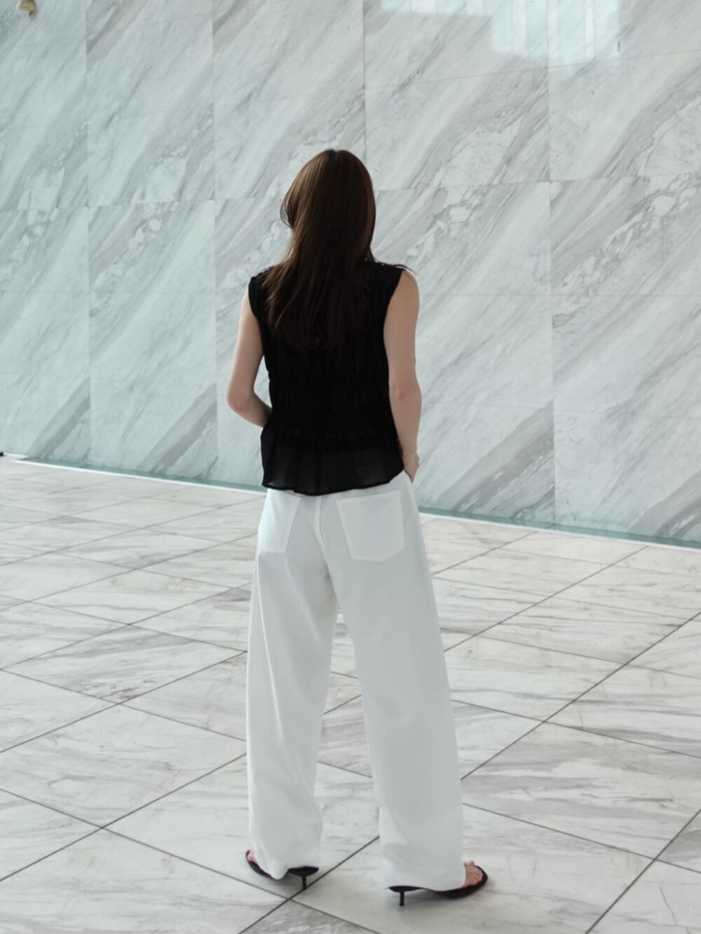 ホワイト系のデニムパンツ、ブラック系のシャツ/ブラウスを着用したレディースの春コーディネートの2枚目の写真