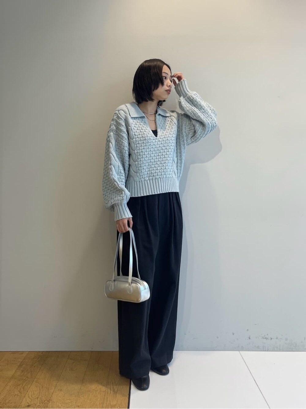 ブルー系のニット/セーター、ブラック系のその他パンツ、シルバー系のハンドバッグを着用したレディースの秋コーディネートの2枚目の写真