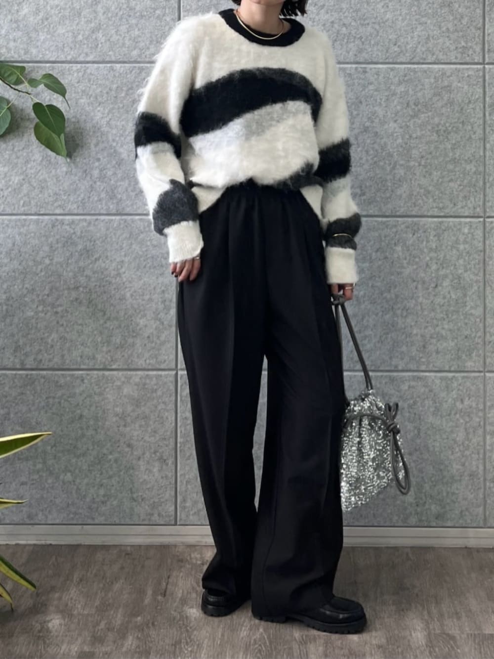 シルバー系のショルダーバッグ、グレー系のニット/セーター、ブラック系のその他パンツを着用したレディースの冬コーディネートの5枚目の写真