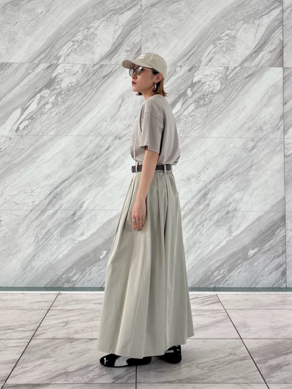 グリーン系のスカート、グレー系のTシャツ/カットソーを着用したレディースの春コーディネートの3枚目の写真