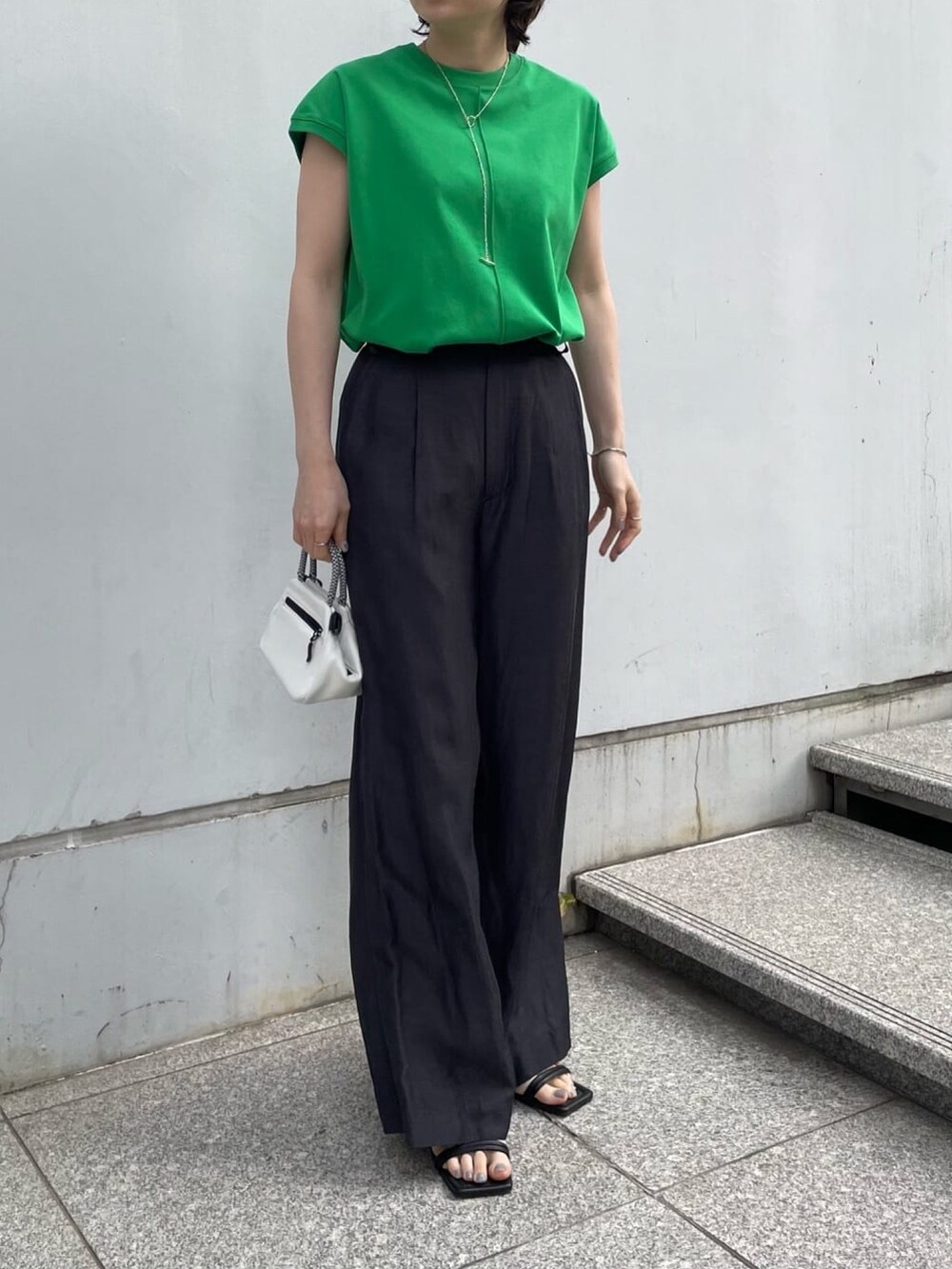 グレー系のその他パンツ、ホワイト系のショルダーバッグ、ブラック系のサンダルを着用したレディースの夏コーディネートの2枚目の写真