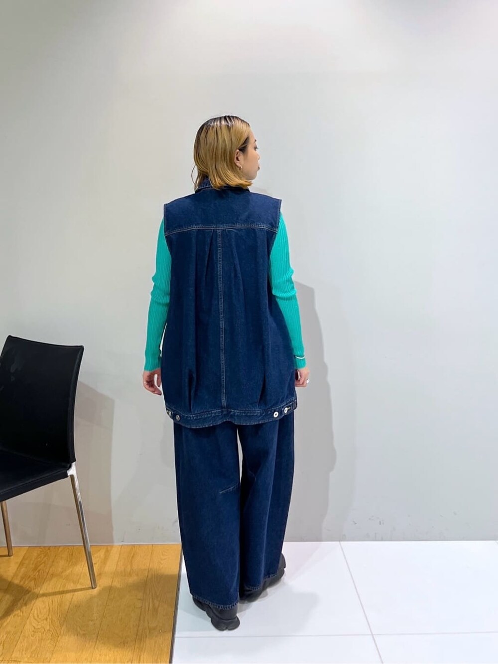 ブルー系のデニムジャケット、グリーン系のニット/セーター、ブルー系のデニムパンツを着用したレディースの冬コーディネートの4枚目の写真