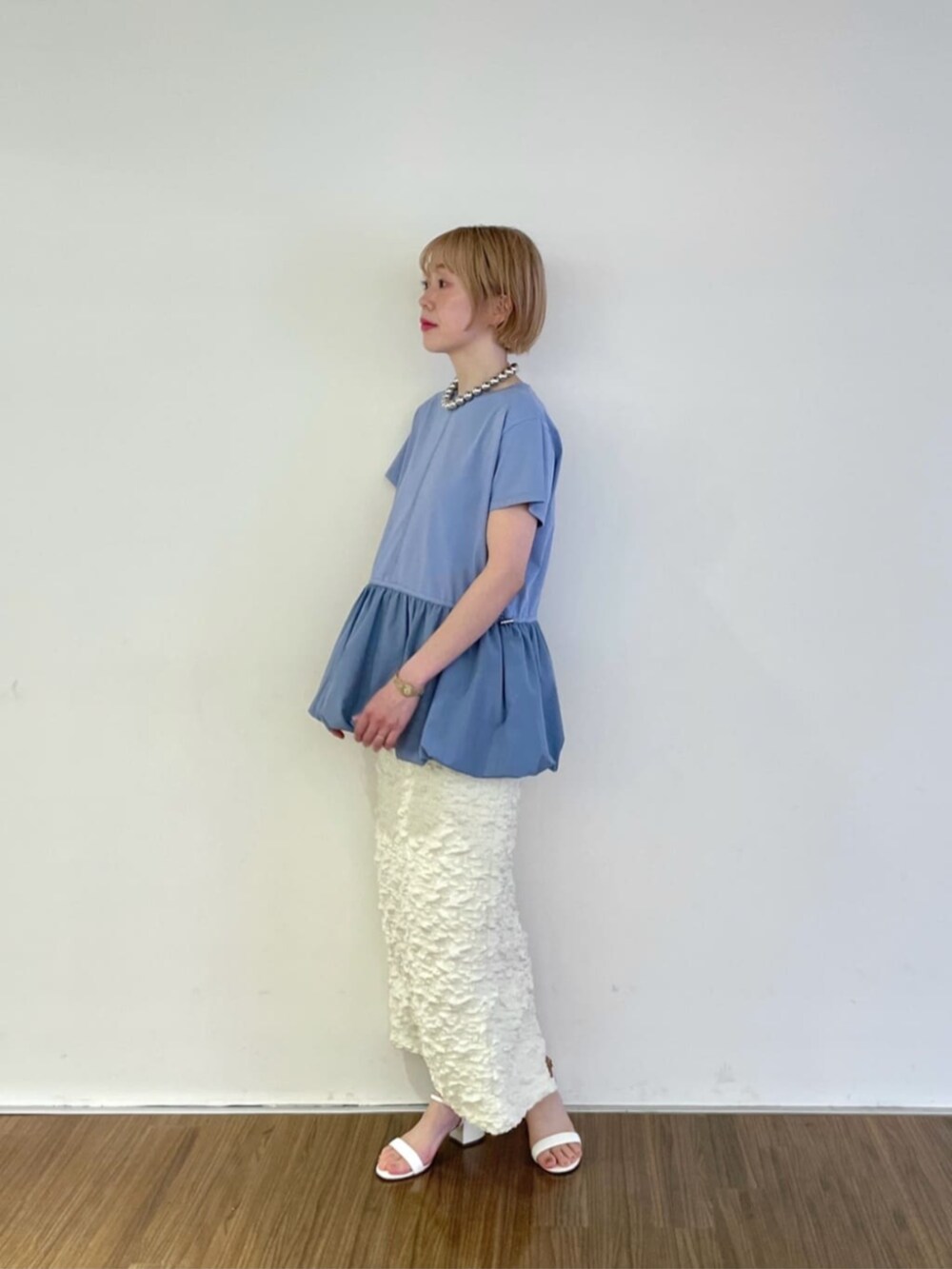 ホワイト系のスカート、ブルー系のTシャツ/カットソー、シルバー系のネックレスを着用したレディースの春コーディネートの3枚目の写真