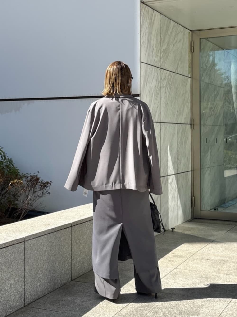 グレー系のその他パンツ、グレー系のワンピース、ホワイト系のTシャツ/カットソーを着用したレディースの春コーディネートの3枚目の写真