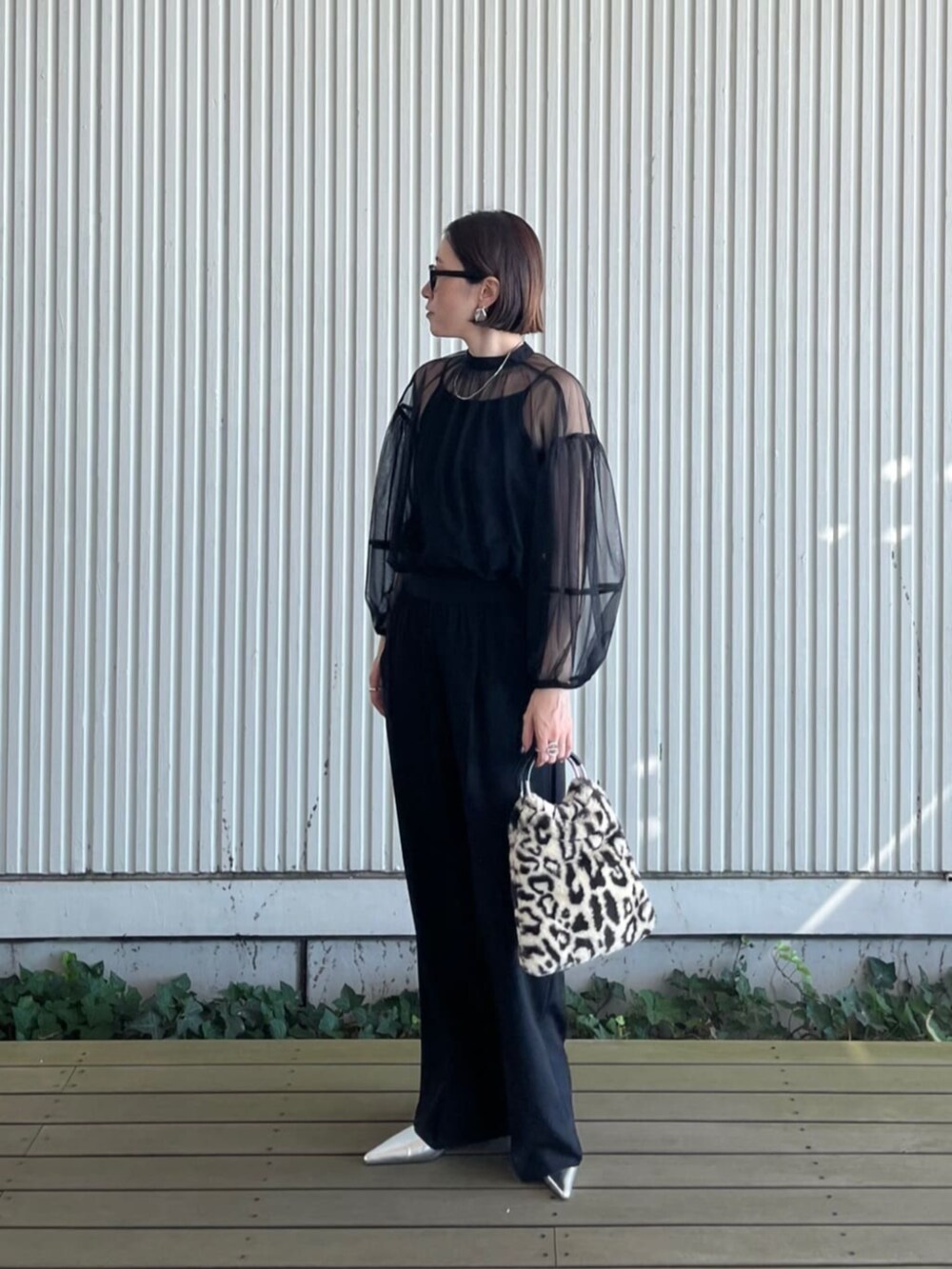 ブラック系のシャツ/ブラウス、ブラック系のその他パンツ、ブラウン系のハンドバッグを着用したレディースの秋コーディネートの4枚目の写真