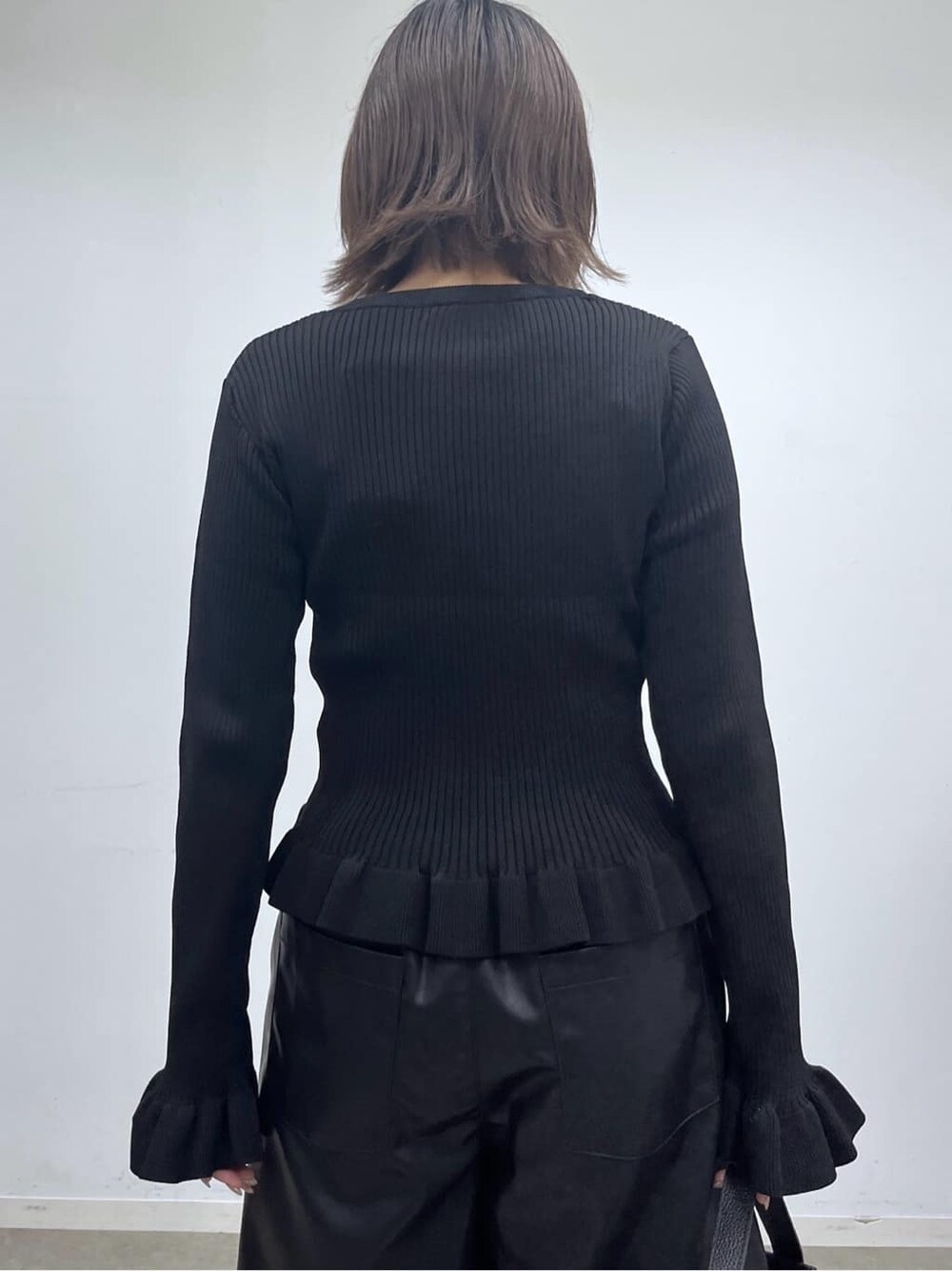 ブラック系のニット/セーター、ブラック系のその他パンツ、ブラック系のハンドバッグを着用したレディースの秋コーディネートの8枚目の写真