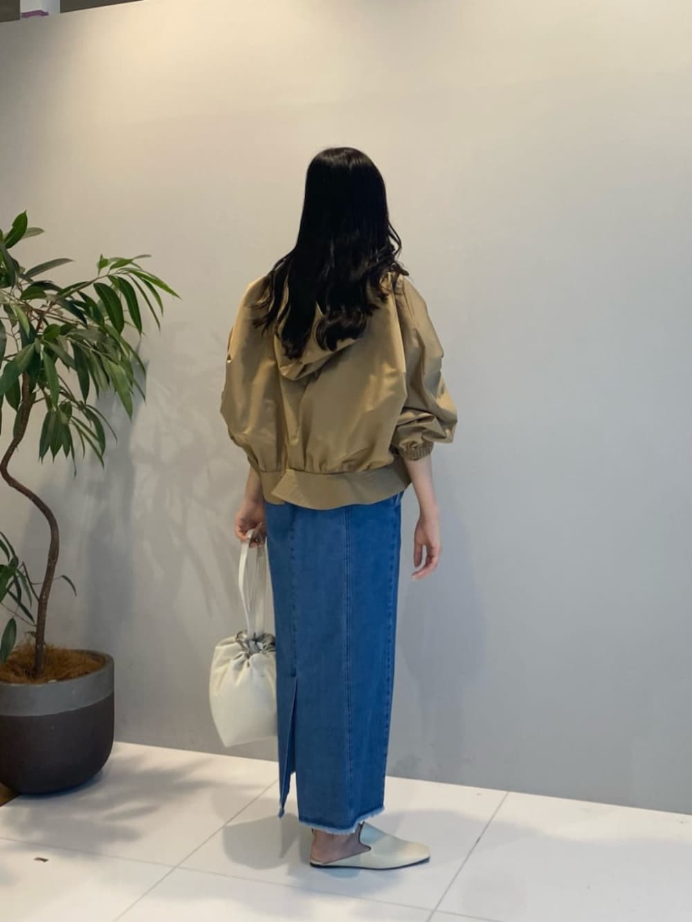 ブルー系のデニムスカート、ベージュ系のブルゾン、ベージュ系のTシャツ/カットソーを着用したレディースの秋コーディネートの3枚目の写真