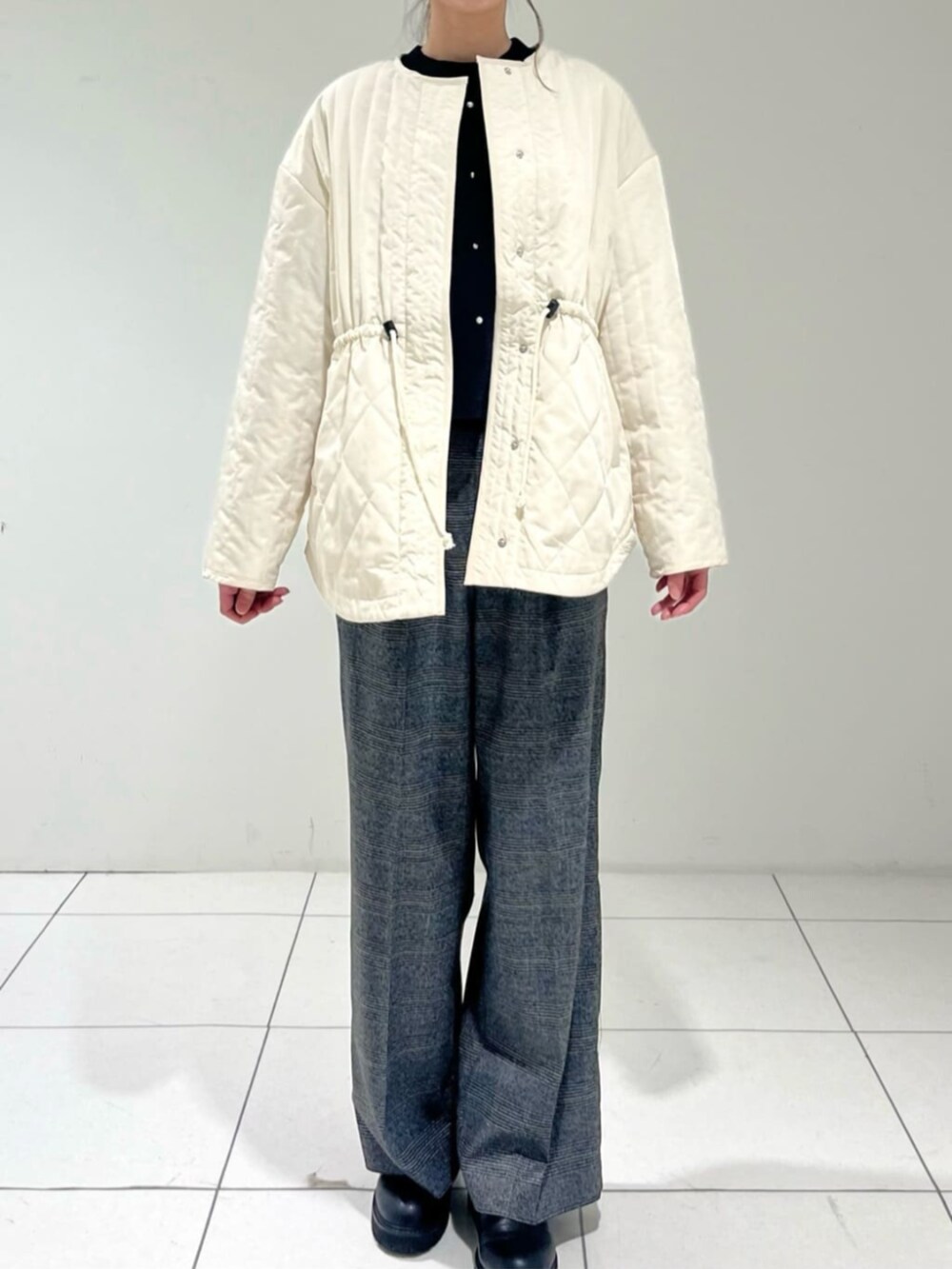 ホワイト系のその他アウター、グレー系のその他パンツ、ブラック系のニット/セーターを着用したレディースの冬コーディネートの4枚目の写真