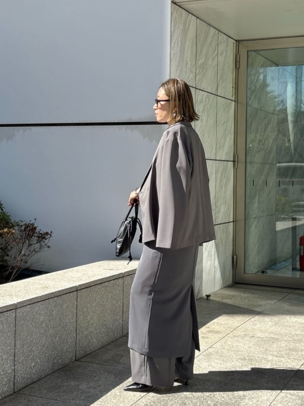 グレー系のその他パンツ、グレー系のワンピース、ホワイト系のTシャツ/カットソーを着用したレディースの春コーディネートの4枚目の写真