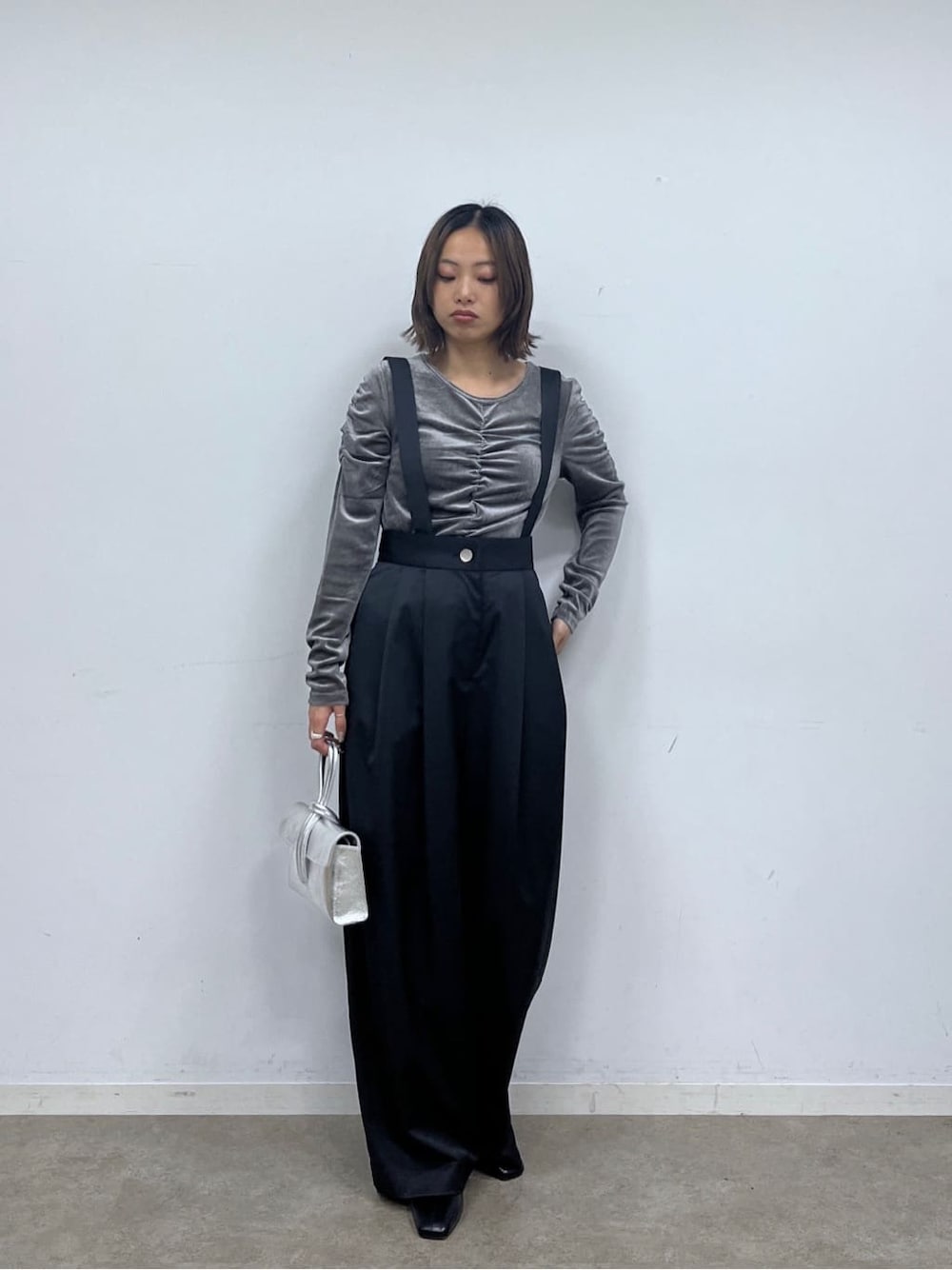 ブラック系のサロペット/オーバーオール、グレー系のTシャツ/カットソー、シルバー系のハンドバッグを着用したレディースの秋コーディネートの2枚目の写真