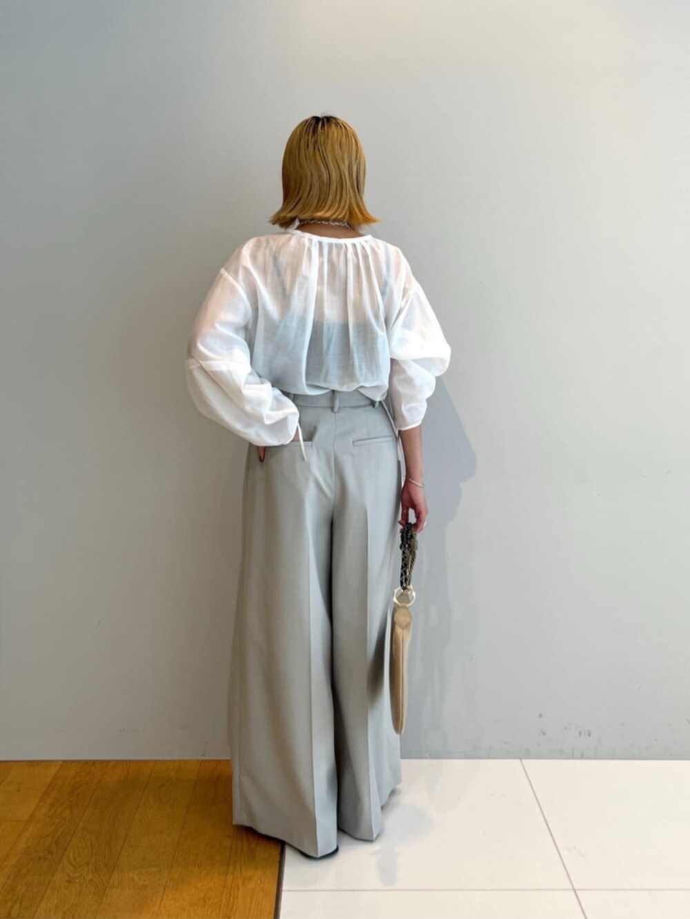 ベージュ系のその他パンツ、ホワイト系のシャツ/ブラウス、ベージュ系のハンドバッグを着用したレディースの春コーディネートの4枚目の写真