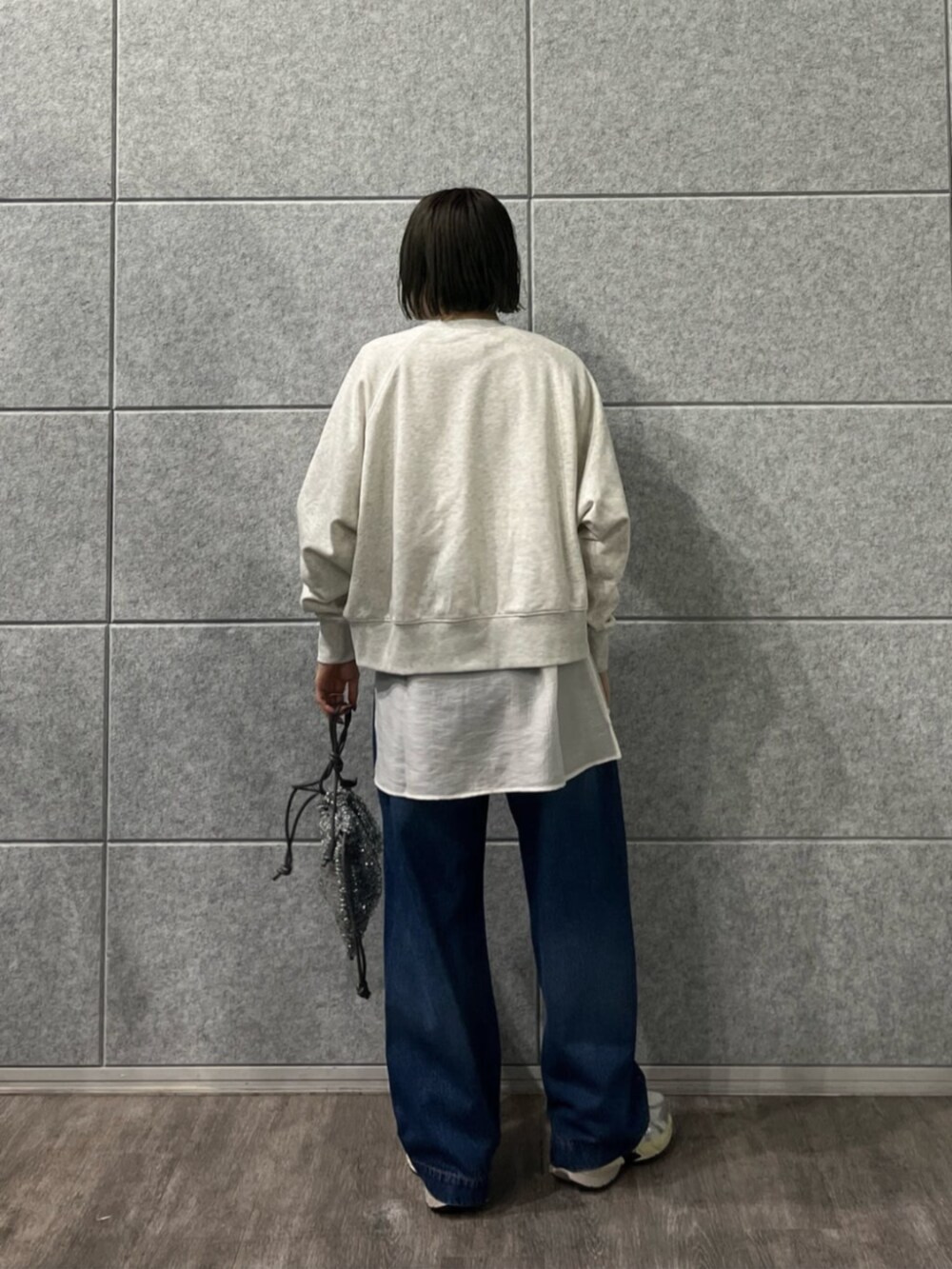 シルバー系のショルダーバッグ、ブルー系のデニムパンツ、ホワイト系のTシャツ/カットソーを着用したレディースの冬コーディネートの2枚目の写真