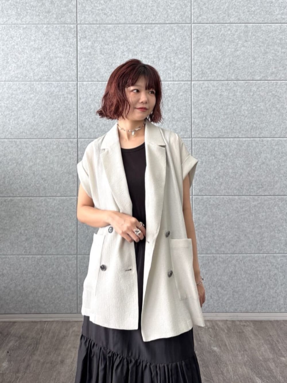 グレー系のテーラードジャケット、ブラック系のスカート、ブラック系のハンドバッグを着用したレディースの夏コーディネートの4枚目の写真