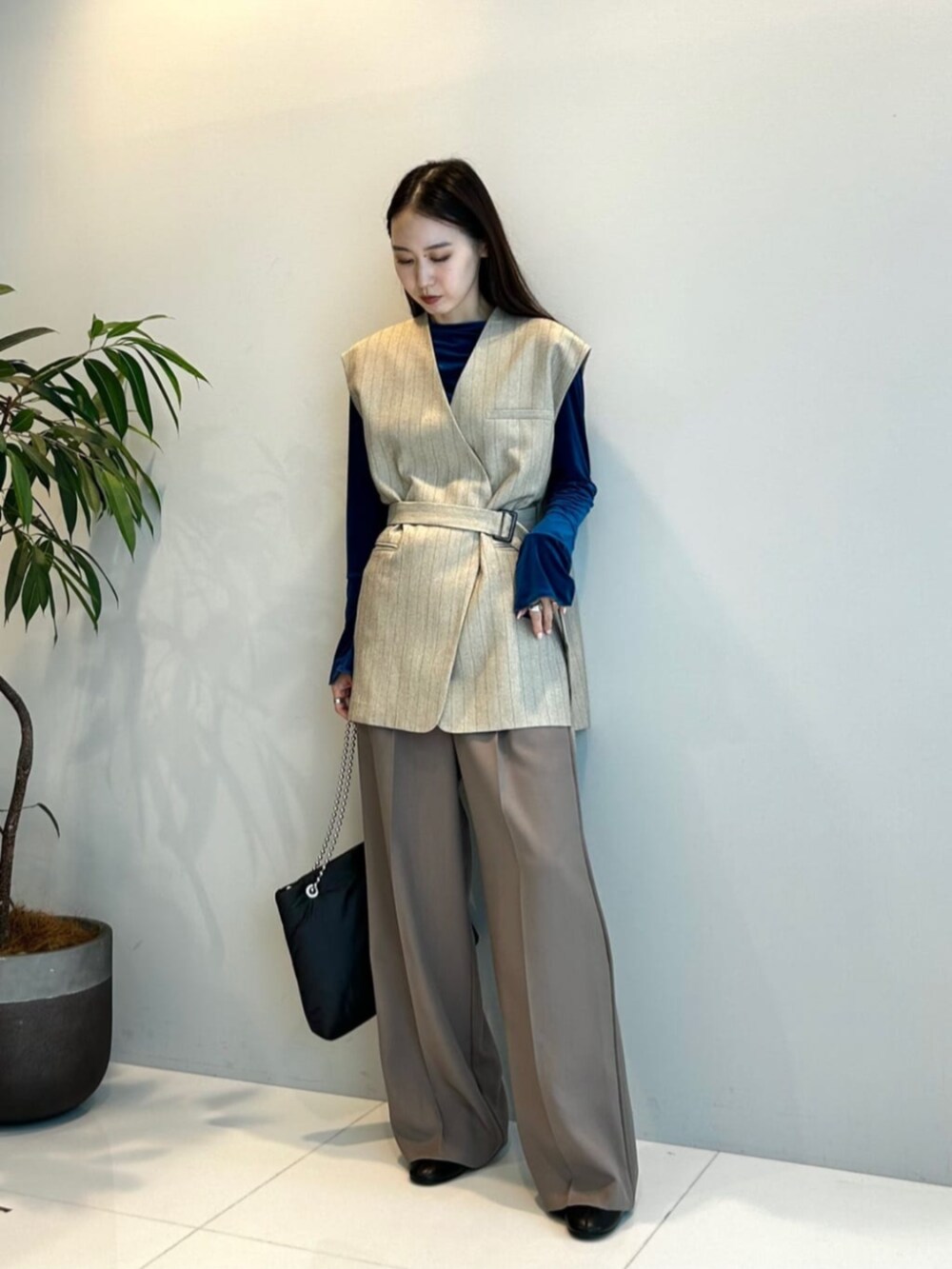 ブラウン系のその他パンツ、ベージュ系のベスト、ブルー系のTシャツ/カットソーを着用したレディースの秋コーディネートの3枚目の写真