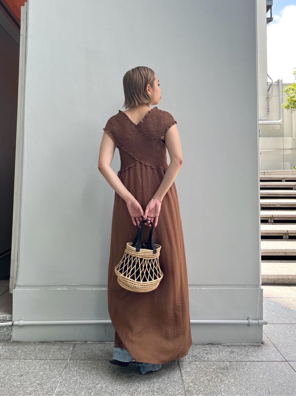 ブラウン系のワンピース、ブルー系のデニムパンツ、ブラック系のハンドバッグを着用したレディースの夏コーディネートの5枚目の写真