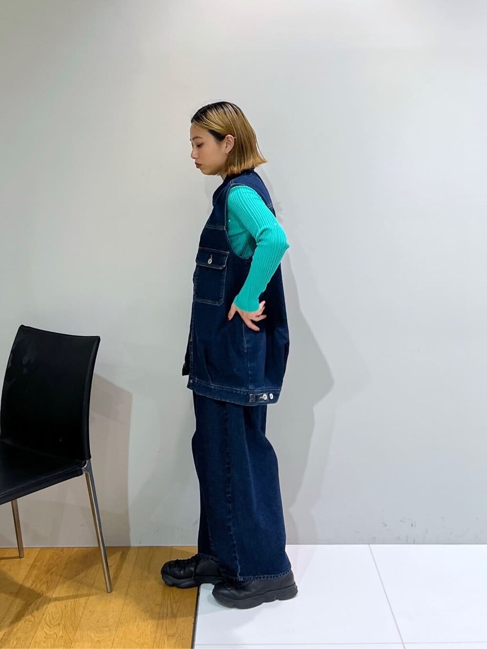 ブルー系のデニムジャケット、グリーン系のニット/セーター、ブルー系のデニムパンツを着用したレディースの冬コーディネートの3枚目の写真