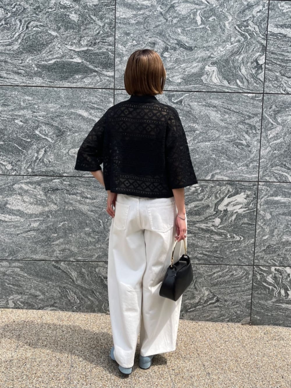 ホワイト系のデニムパンツ、ブラック系のハンドバッグ、ブラック系のシャツ/ブラウスを着用したレディースの夏コーディネートの4枚目の写真