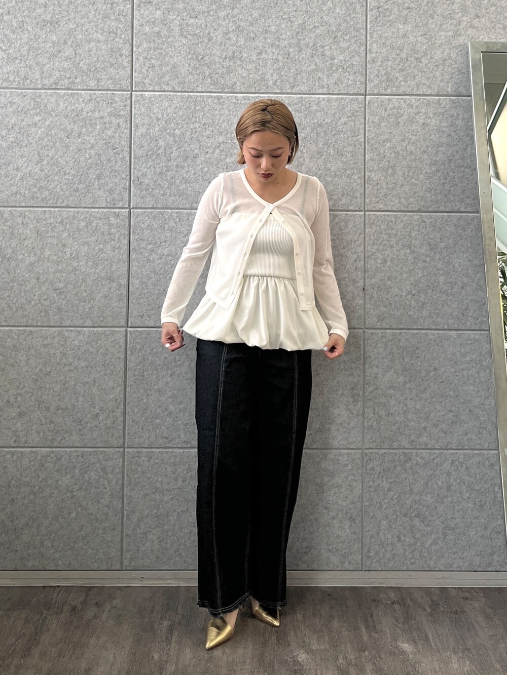 ブルー系のデニムパンツ、ホワイト系のアンサンブルを着用したレディースの春コーディネートの2枚目の写真