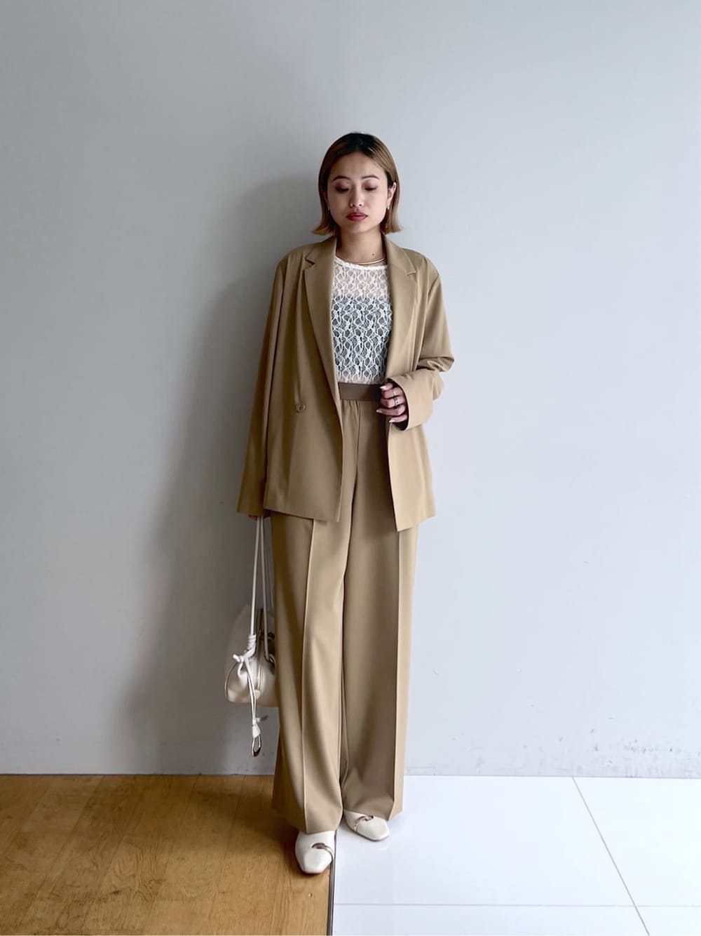 イエロー系のテーラードジャケット、ホワイト系のTシャツ/カットソー、イエロー系のその他パンツを着用したレディースの春コーディネートの2枚目の写真