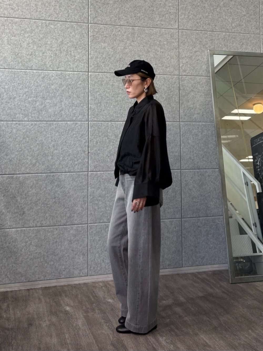 グレー系のデニムパンツ、ブラック系のシャツ/ブラウスを着用したレディースの春コーディネートの2枚目の写真