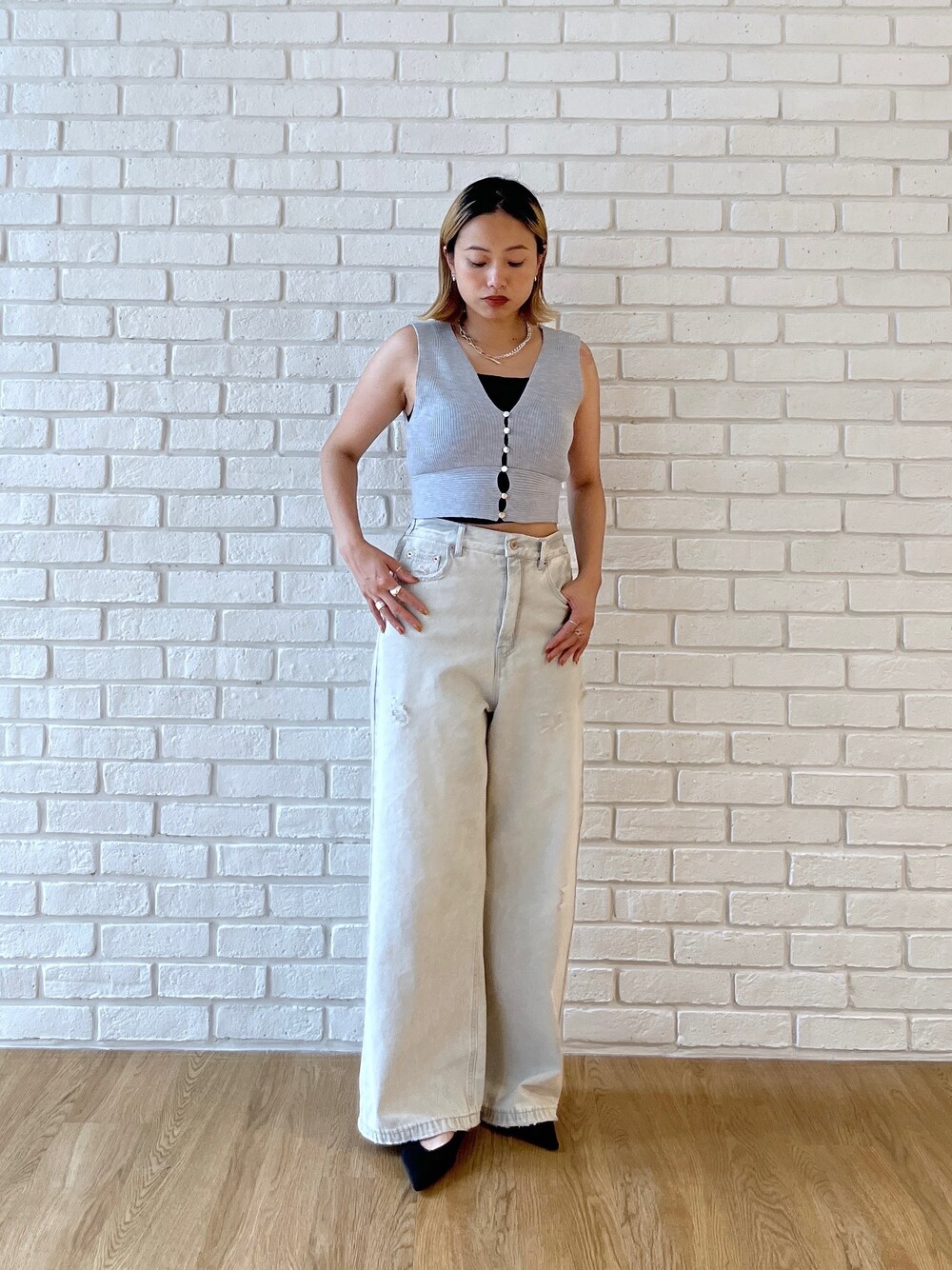 グレー系のニット/セーター、グレー系のデニムパンツを着用したレディースの夏コーディネートの5枚目の写真
