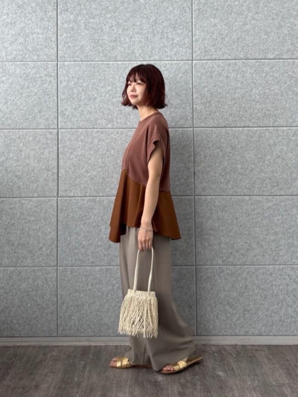 ベージュ系のその他パンツ、ブラウン系のTシャツ/カットソー、ホワイト系のハンドバッグを着用したレディースの夏コーディネートの3枚目の写真