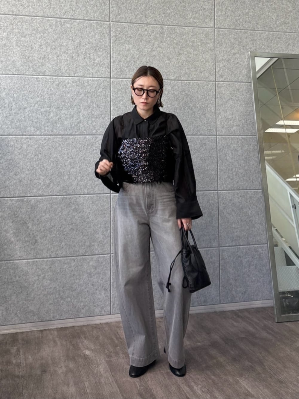 グレー系のデニムパンツ、ブラック系のタンクトップ、ブラック系のシャツ/ブラウスを着用したレディースの春コーディネートの2枚目の写真