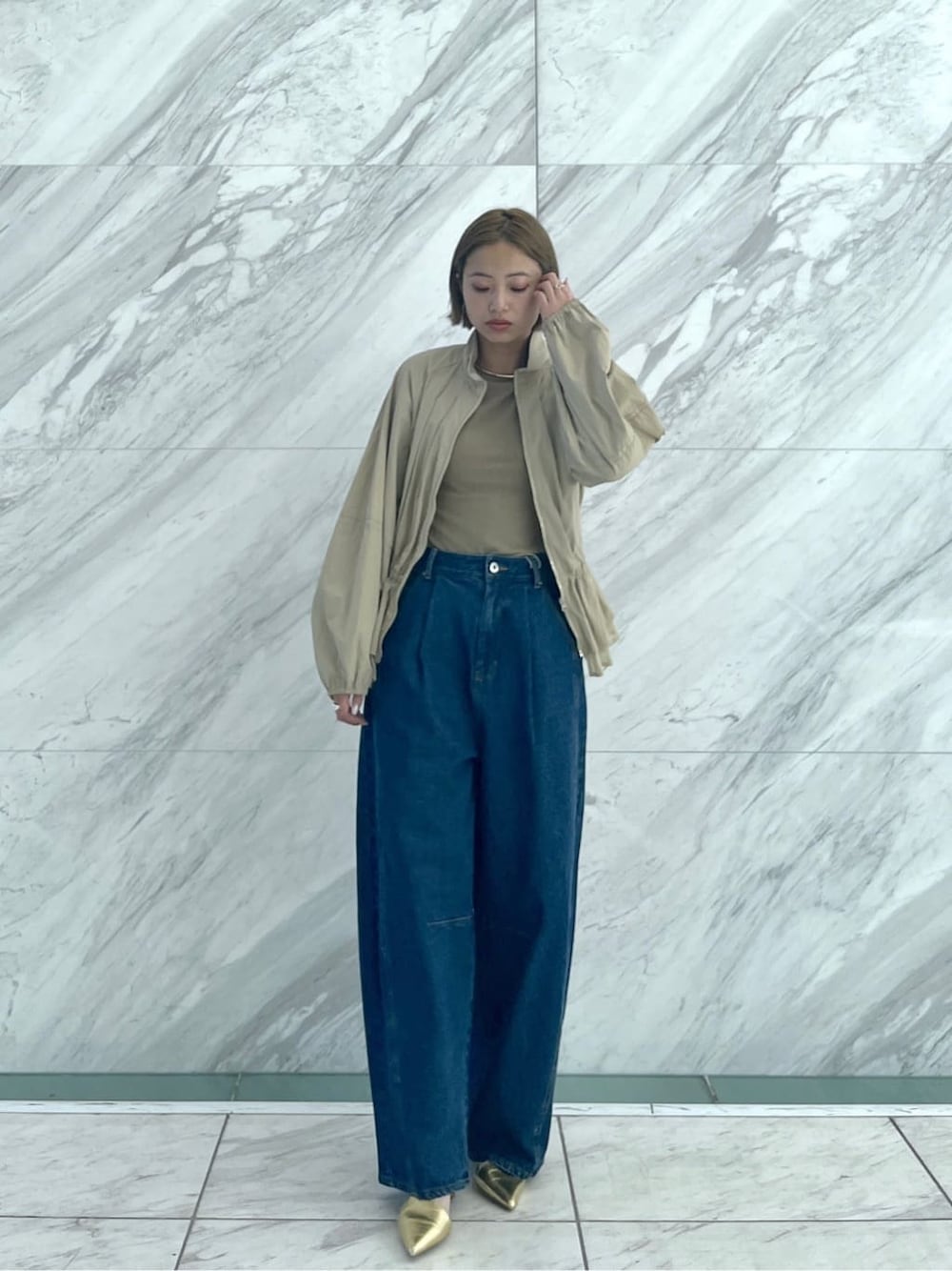 グリーン系のTシャツ/カットソー、ブルー系のデニムパンツ、ベージュ系のブルゾンを着用したレディースの春コーディネートの9枚目の写真