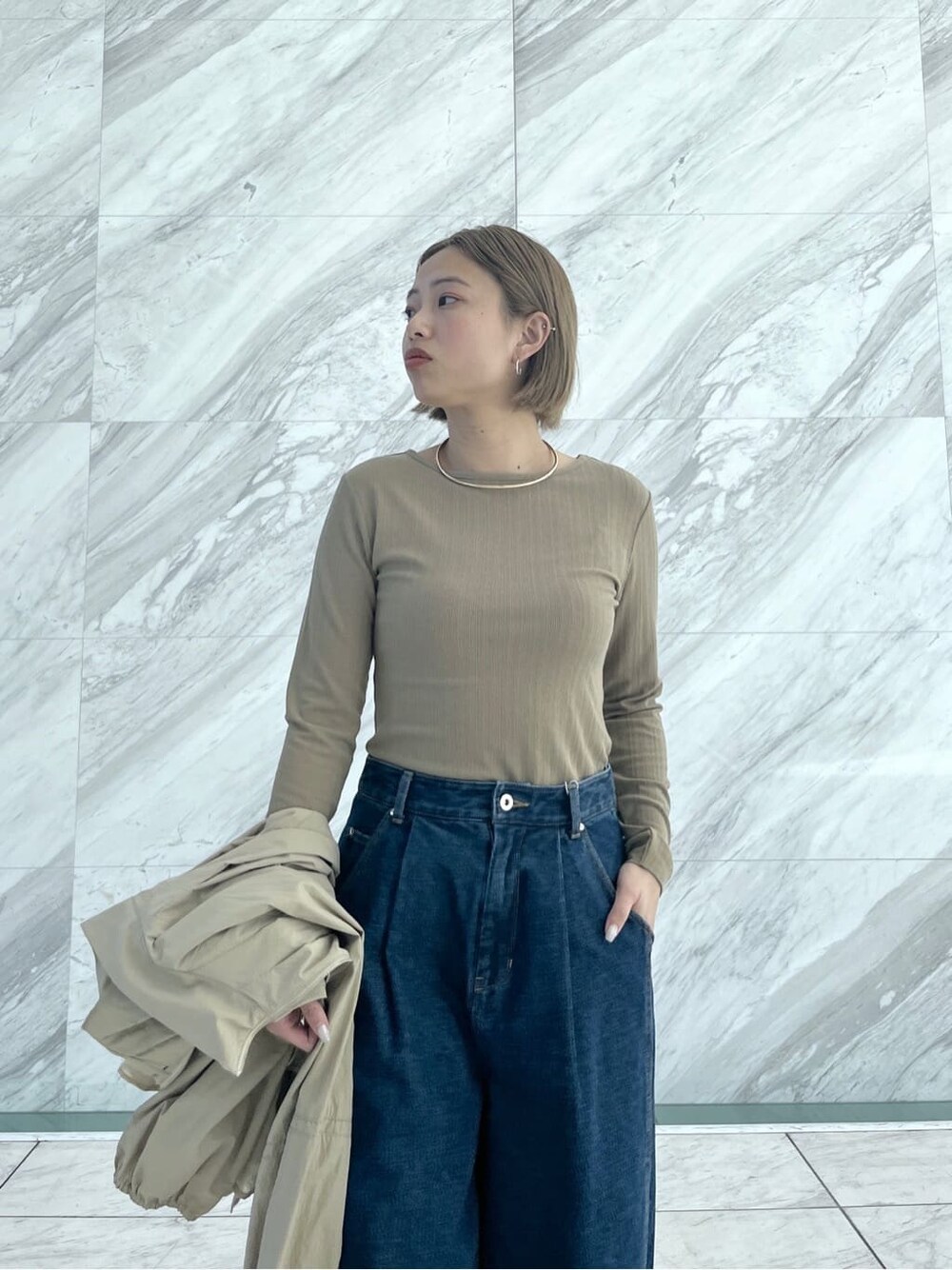 グリーン系のTシャツ/カットソー、ブルー系のデニムパンツ、ベージュ系のブルゾンを着用したレディースの春コーディネートの5枚目の写真
