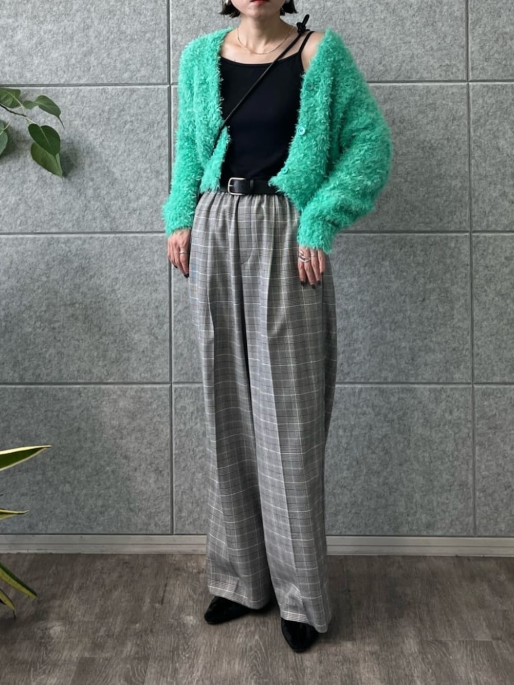 ブラック系のショルダーバッグ、グレー系のその他パンツ、グリーン系のカーディガン/ボレロを着用したレディースの冬コーディネートの3枚目の写真