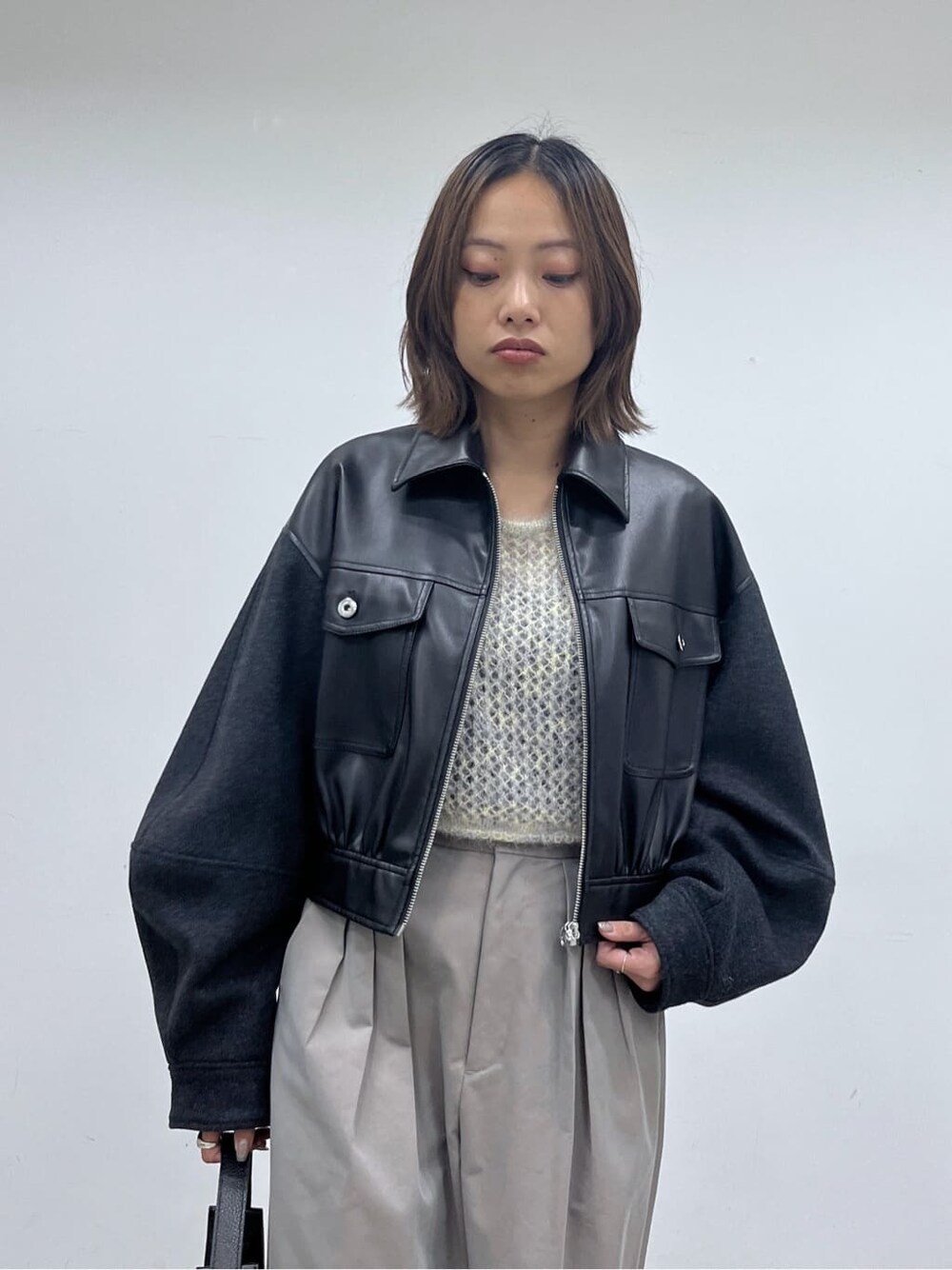 ブラック系のブルゾン、ベージュ系のニット/セーター、グレー系のその他パンツを着用したレディースの冬コーディネートの6枚目の写真