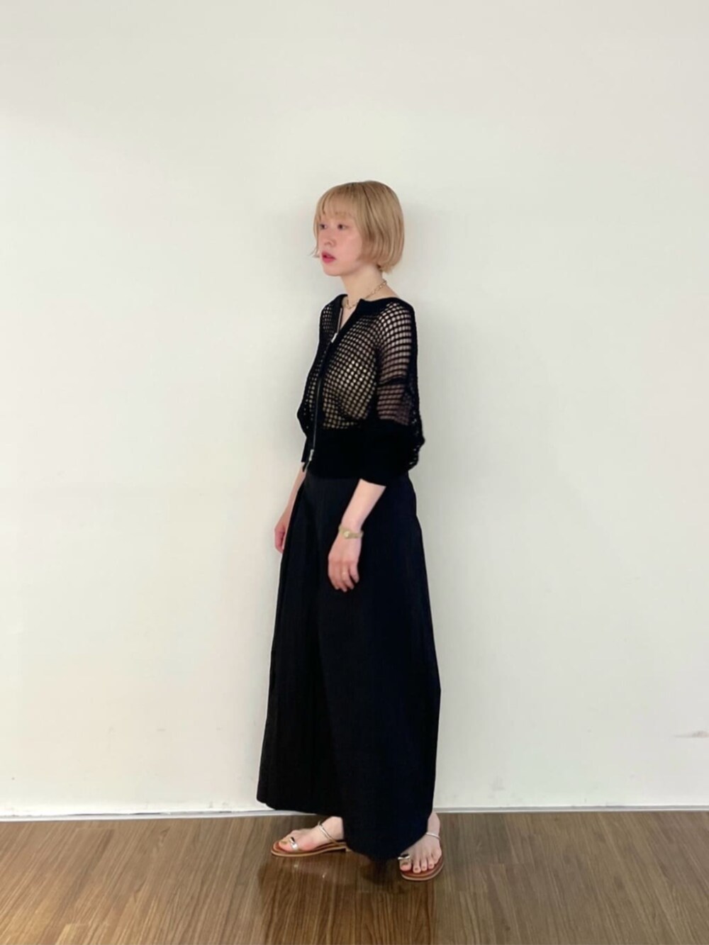 ブラック系のその他パンツ、ゴールド系のチューブトップ、ブラック系のカーディガン/ボレロを着用したレディースの夏コーディネートの2枚目の写真