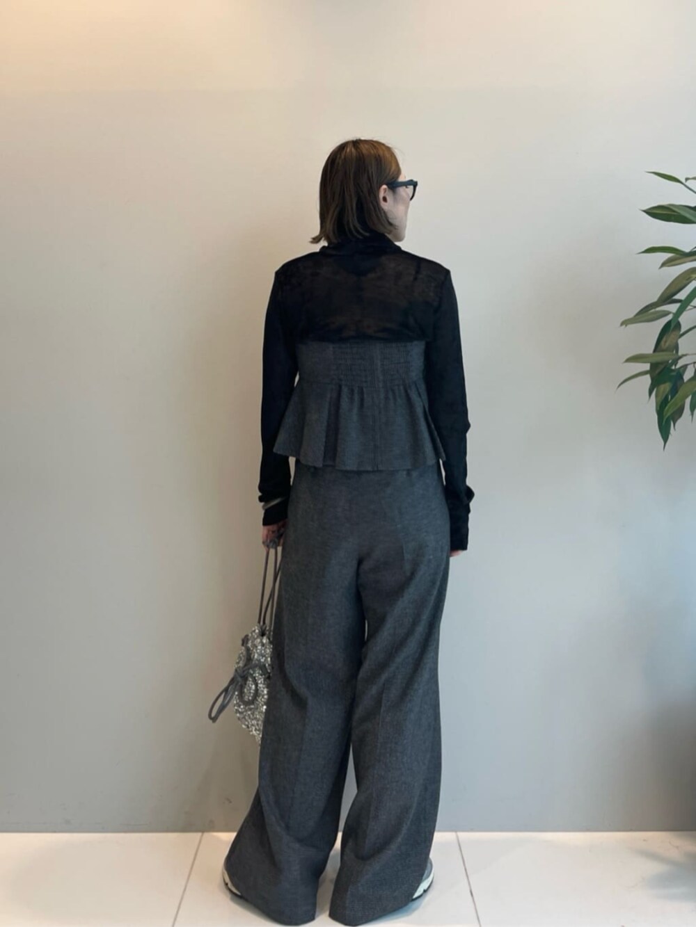 シルバー系のショルダーバッグ、グレー系のその他パンツ、グレー系のベストを着用したレディースの冬コーディネートの2枚目の写真