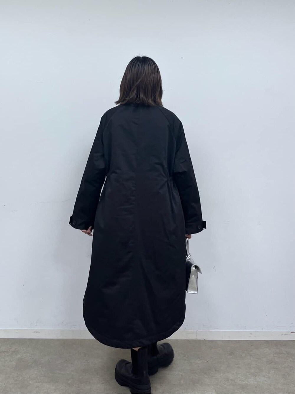 ブラック系のモッズコート、ホワイト系のニット/セーター、ブラック系のその他パンツを着用したレディースの秋コーディネートの5枚目の写真