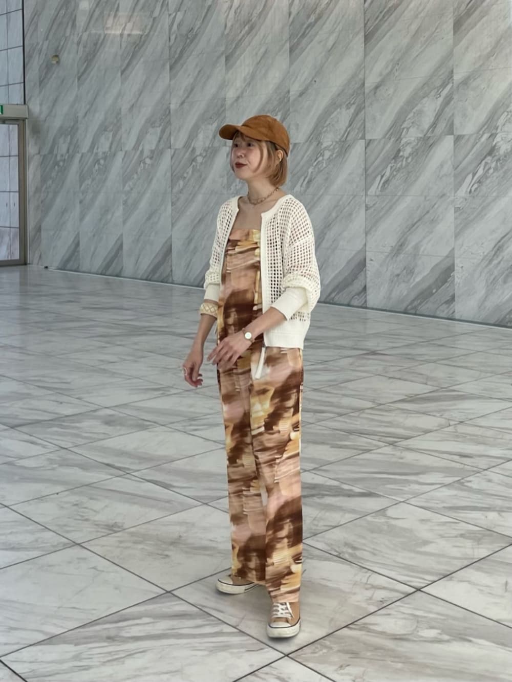 イエロー系のワンピース、ホワイト系のカーディガン/ボレロを着用したレディースの春コーディネートの3枚目の写真