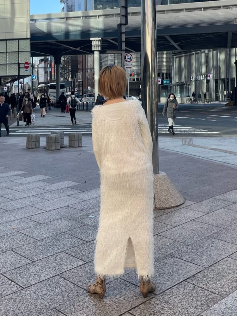 ホワイト系のニット/セーター、ブラウン系のブーツ、ホワイト系のスカートを着用したレディースの冬コーディネートの3枚目の写真