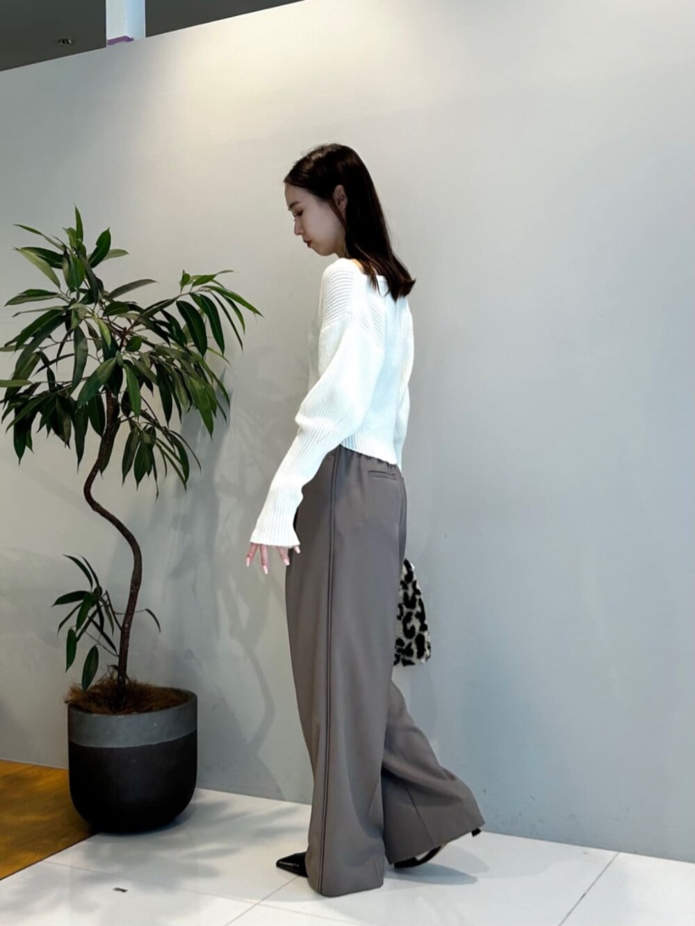 ブラウン系のハンドバッグ、ブラウン系のその他パンツ、ホワイト系のニット/セーターを着用したレディースの秋コーディネートの3枚目の写真