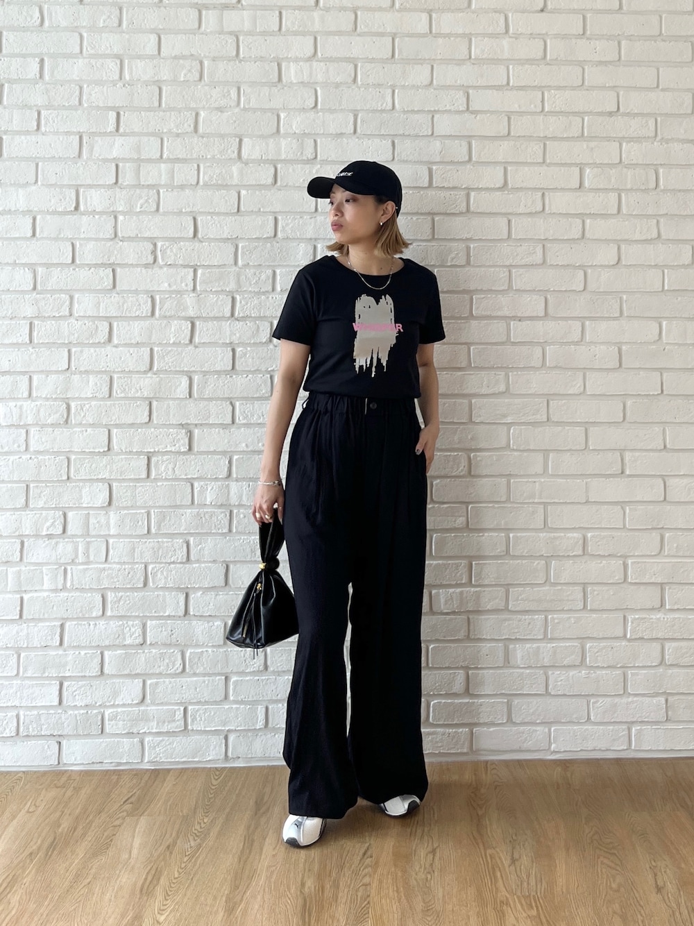 ブラック系のTシャツ/カットソー、ブラック系のその他パンツ、ホワイト系のスニーカーを着用したレディースの夏コーディネートの8枚目の写真