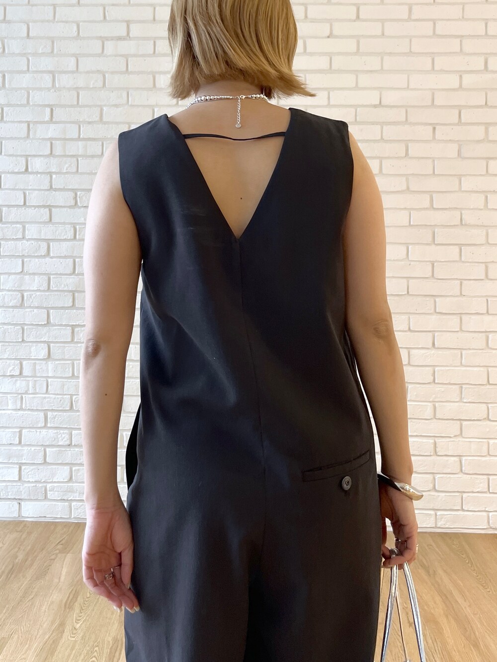 ブラック系のサロペット/オーバーオール、シルバー系のサンダル、シルバー系のネックレスを着用したレディースの春コーディネートの6枚目の写真