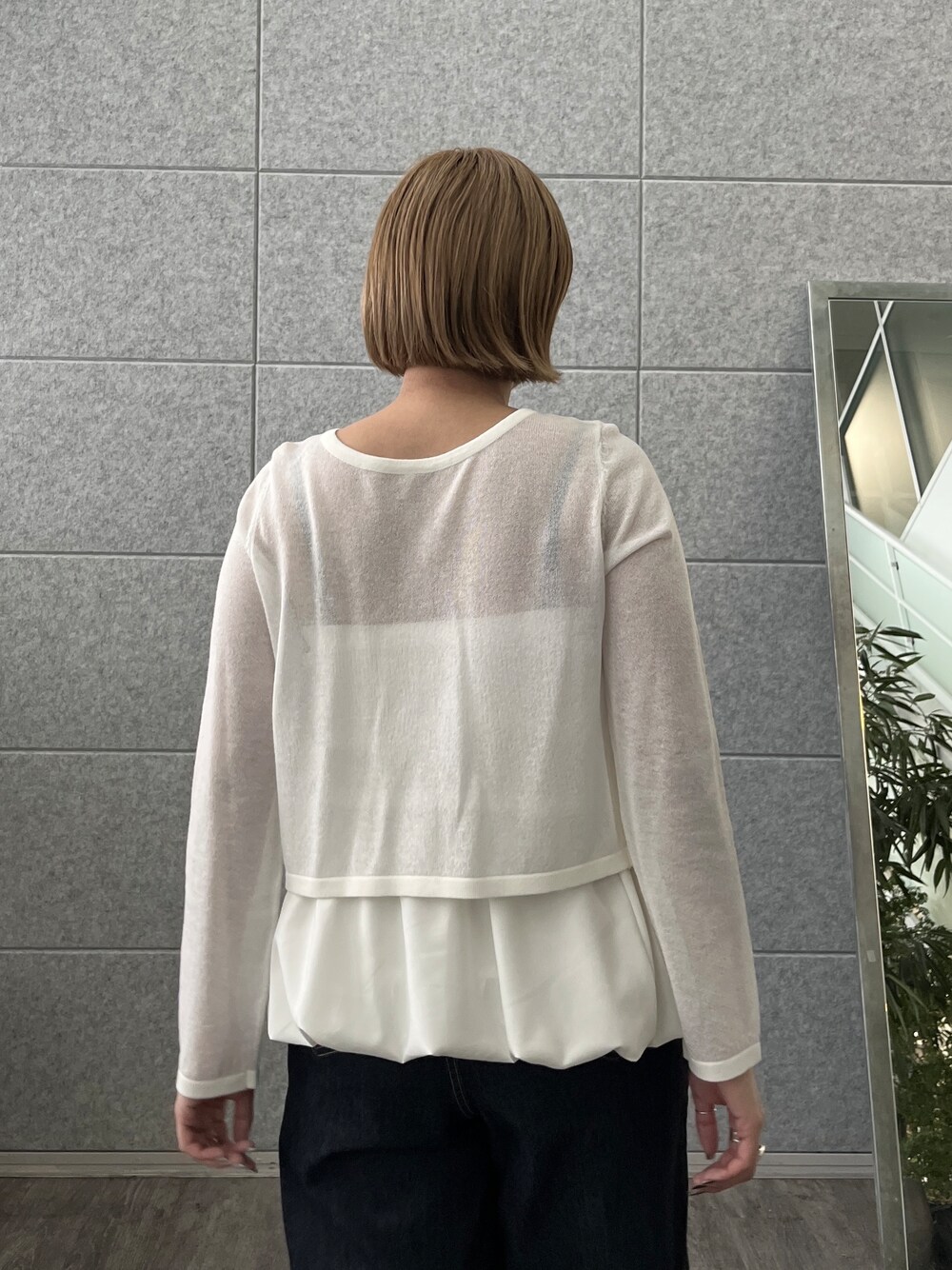 ブルー系のデニムパンツ、ホワイト系のアンサンブルを着用したレディースの春コーディネートの9枚目の写真