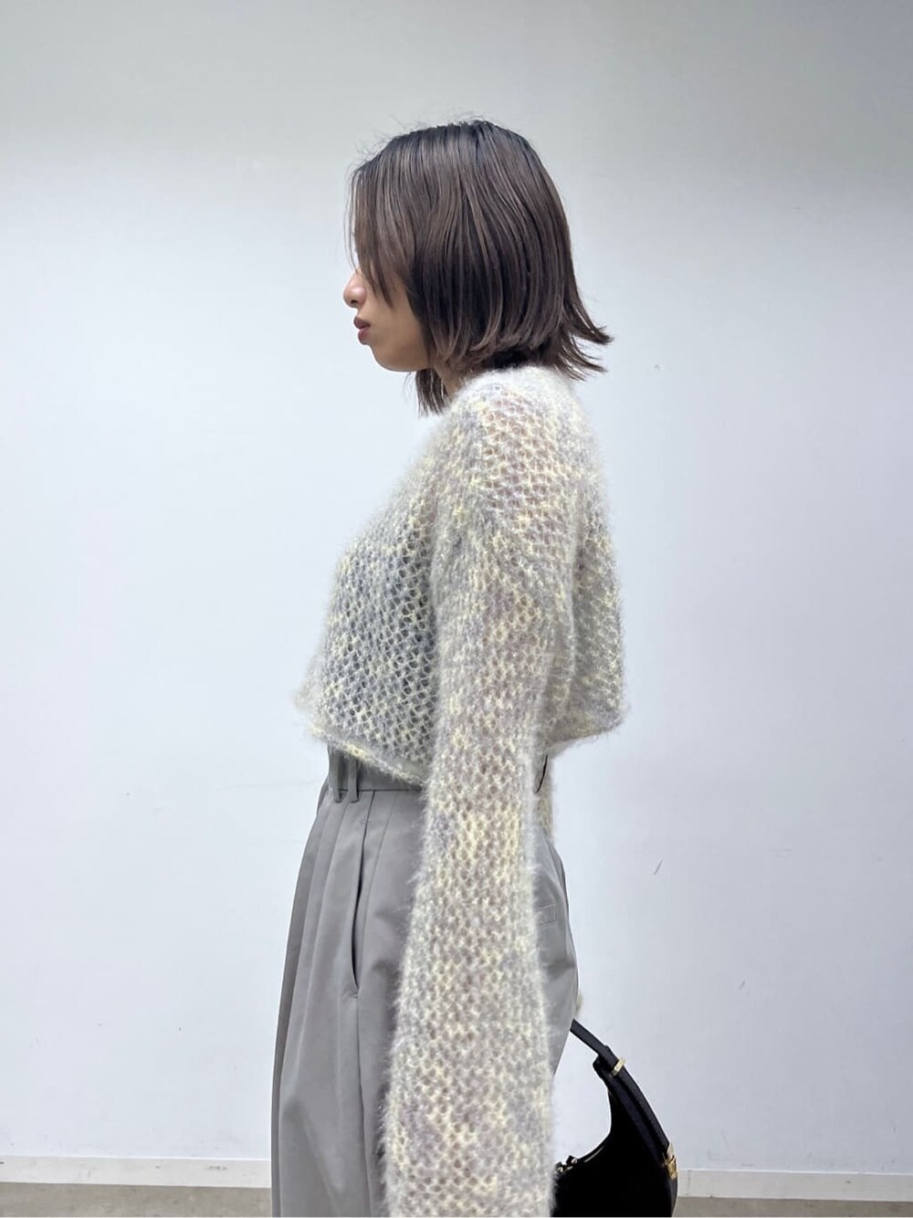 ベージュ系のニット/セーター、グレー系のその他パンツ、ブラック系のショルダーバッグを着用したレディースの冬コーディネートの7枚目の写真