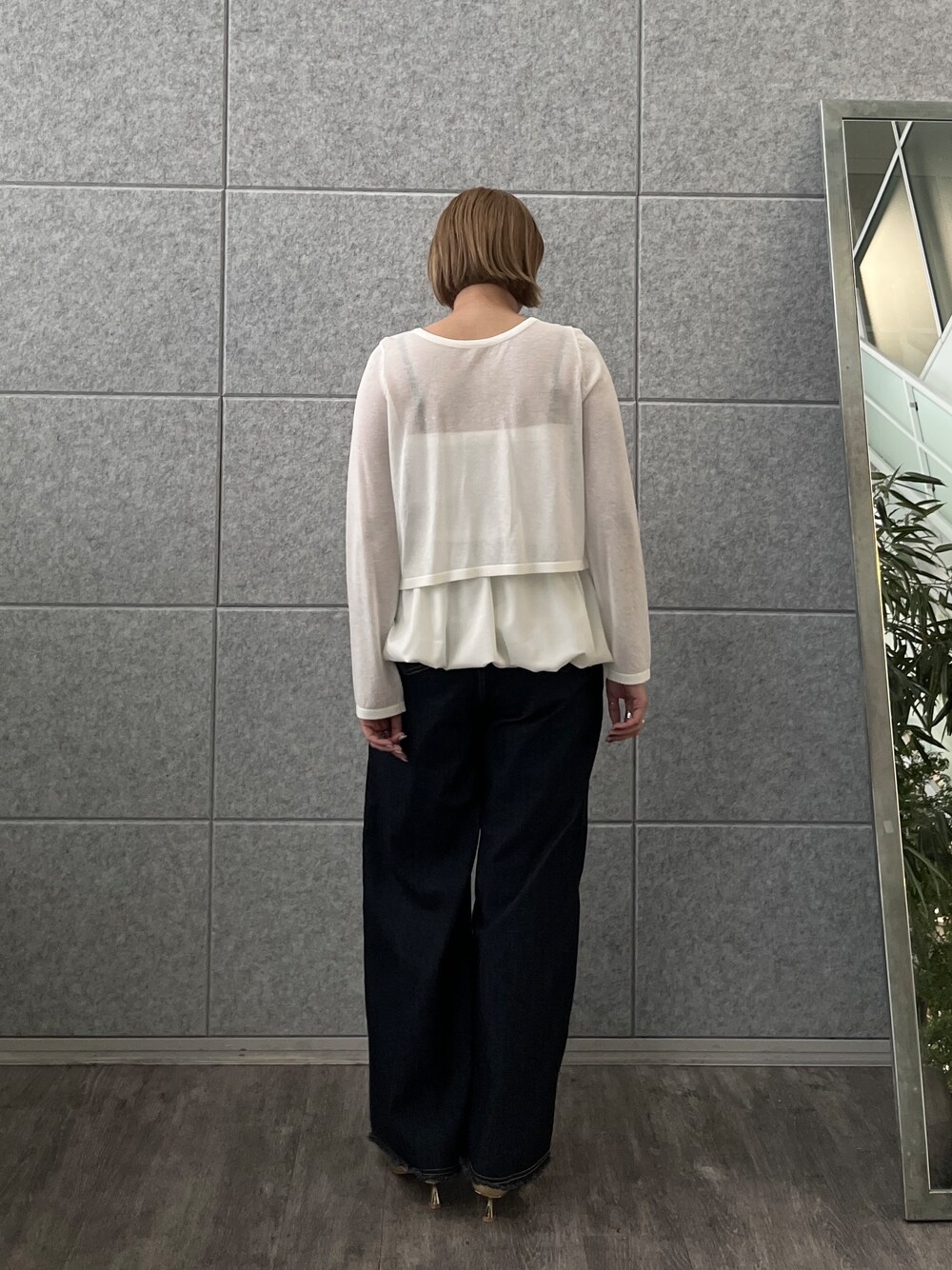 ブルー系のデニムパンツ、ホワイト系のアンサンブルを着用したレディースの春コーディネートの4枚目の写真