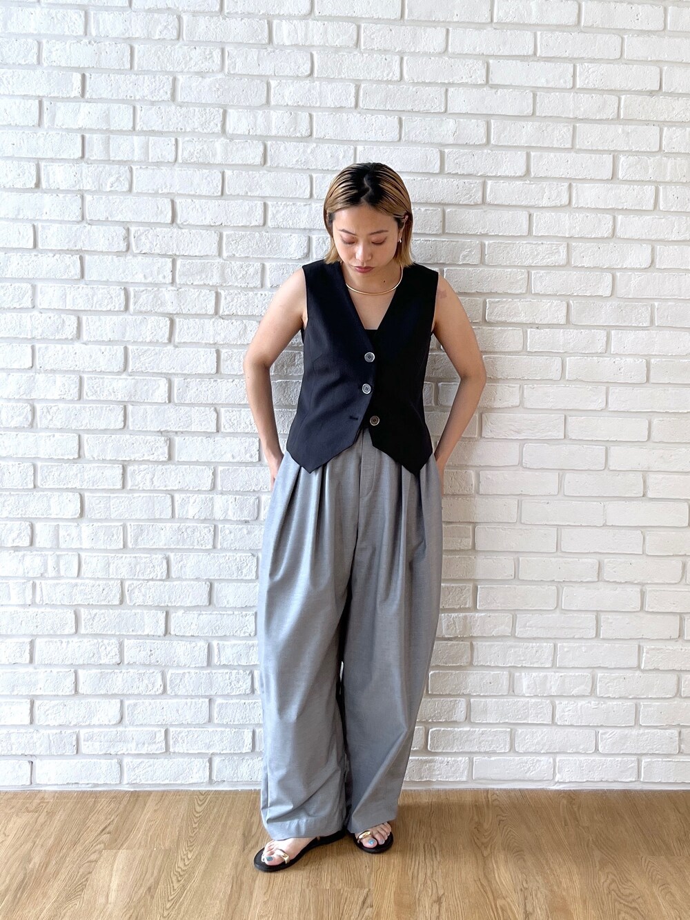 ブラック系のベスト、グレー系のその他パンツを着用したレディースの夏コーディネートの2枚目の写真