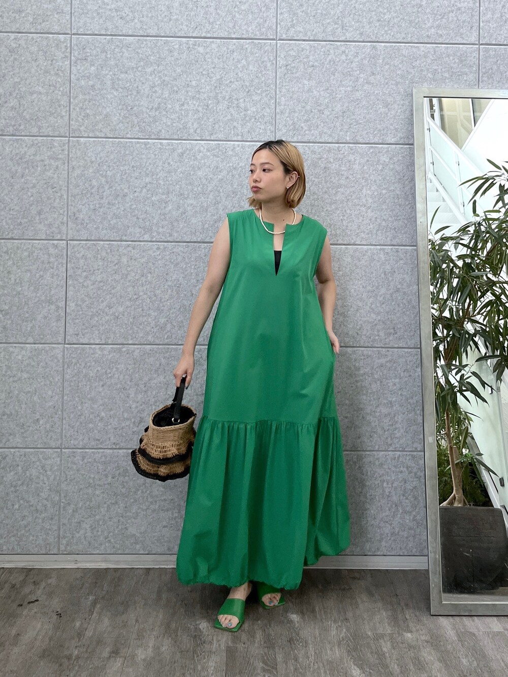 グリーン系のワンピース、ベージュ系のハンドバッグ、グリーン系のサンダルを着用したレディースの夏コーディネートの7枚目の写真