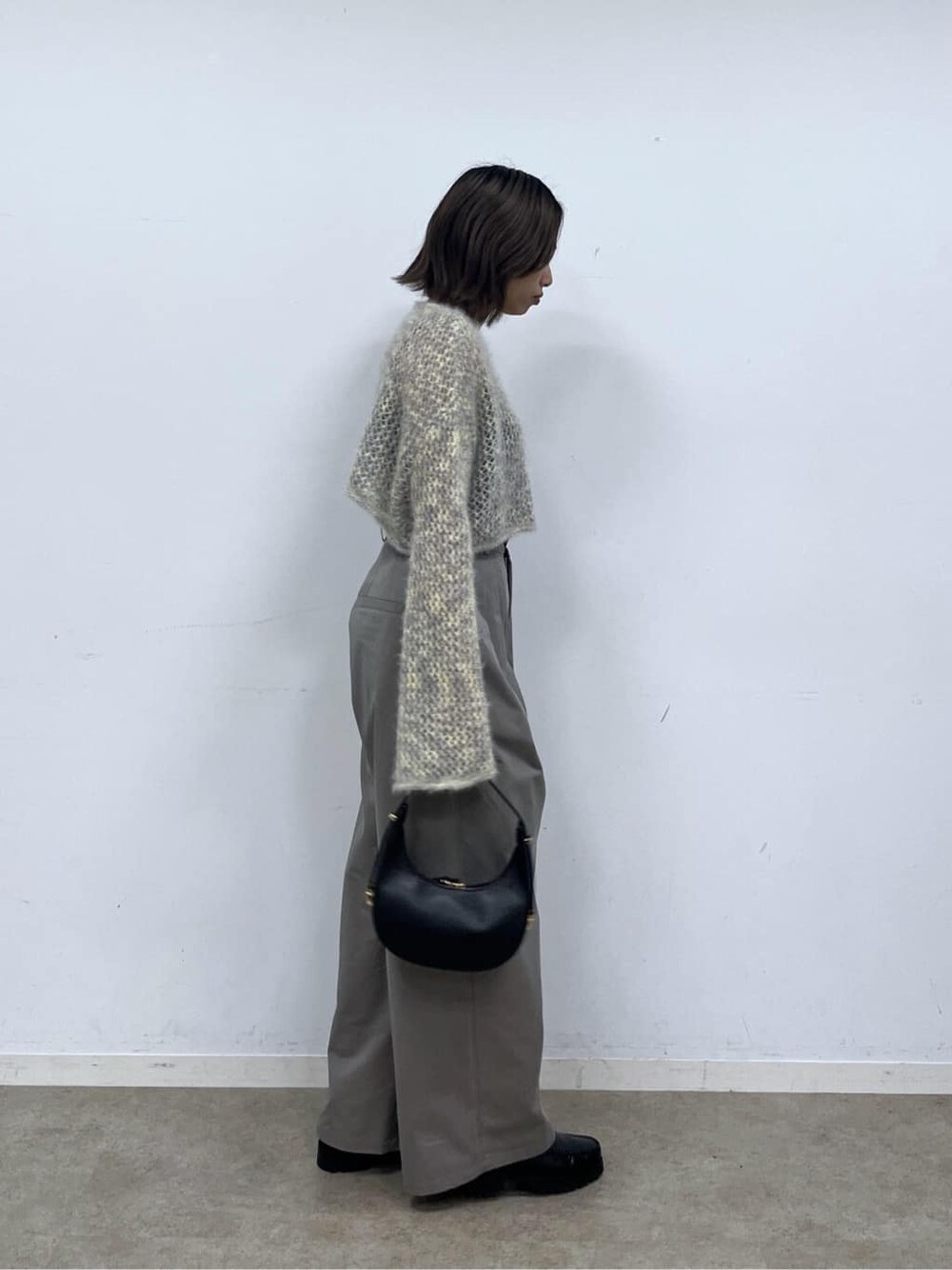 ベージュ系のニット/セーター、グレー系のその他パンツ、ブラック系のショルダーバッグを着用したレディースの冬コーディネートの5枚目の写真
