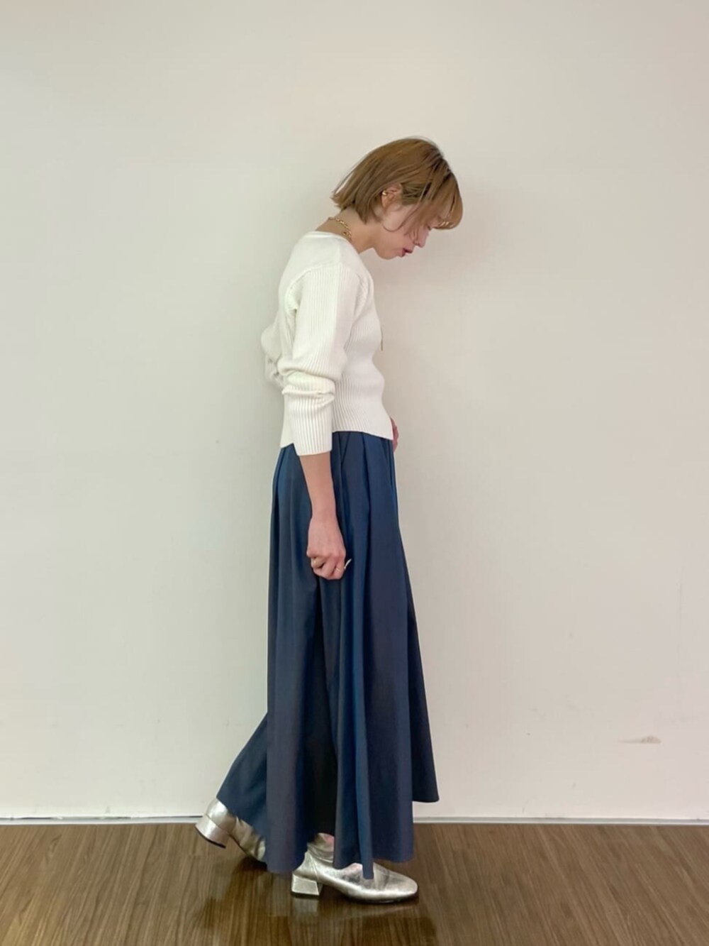ホワイト系のニット/セーター、ブルー系のスカートを着用したレディースの冬コーディネートの2枚目の写真