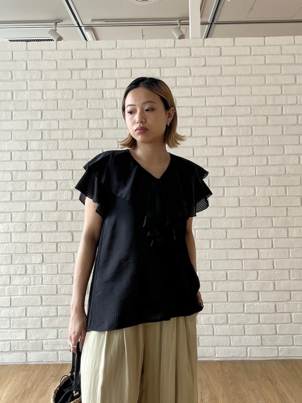 ブラック系のシャツ/ブラウス、グリーン系のその他パンツ、ベージュ系のハンドバッグを着用したレディースの夏コーディネートの5枚目の写真