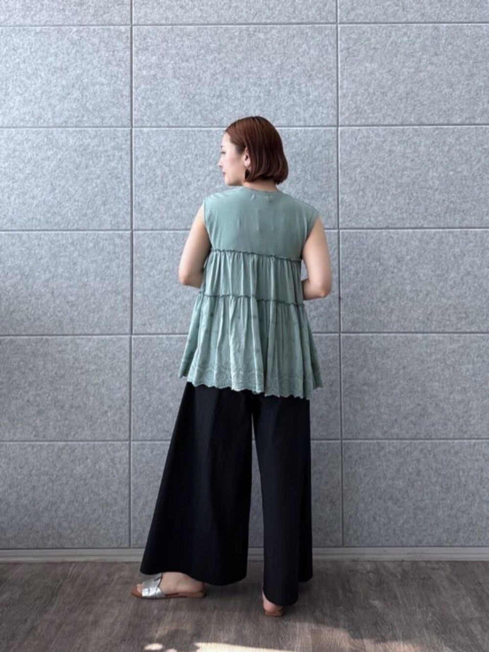 ブラック系のその他パンツ、グリーン系のTシャツ/カットソーを着用したレディースの夏コーディネートの3枚目の写真